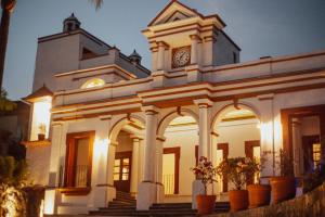 Palacio Del Cobre في تيبوزتلان: مبنى ابيض كبير عليه برج الساعه