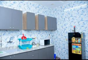 a kitchen with blue and white wallpaper and a refrigerator at Résidence les 3M in Cotonou