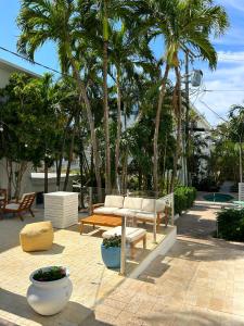 d'une terrasse avec une table, des bancs et des palmiers. dans l'établissement North Beach Hotel, à Fort Lauderdale
