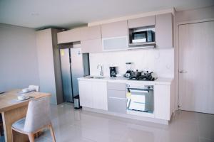 a kitchen with white cabinets and a microwave at Apartaestudio Luxur en Barranquilla in Barranquilla