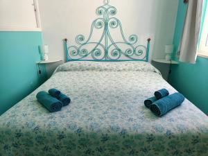 un letto con due cuscini blu sopra di Appartamento Sole a Cala Gonone