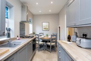 a kitchen with a sink and a table with chairs at Kist Accommodates - Belmont Dene in Knaresborough