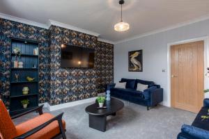 sala de estar con sofá azul y mesa en Kist Accommodates - Belmont Dene, en Knaresborough