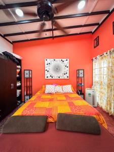 ein Schlafzimmer mit einem großen Bett mit orangefarbenen Wänden in der Unterkunft Las Cabañitas in Pereira