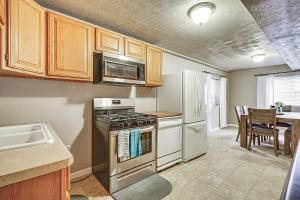 a kitchen with a stove and refrigerator and a table at Pet-Friendly Utah Apartment 2 Mi to Amphitheatre in West Valley City