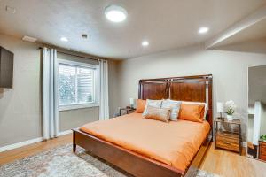 a bedroom with a bed with orange sheets and a window at Pet-Friendly Utah Apartment 2 Mi to Amphitheatre in West Valley City