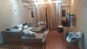 a living room with a couch and a clock on the wall at appartement confortable in Tangier