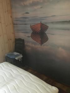 a bedroom with a bed and a painting of an umbrella at Rønlund Hyttepark, Midgard in Ron