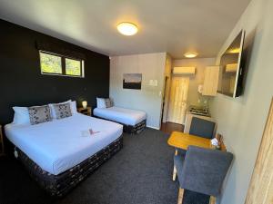 um quarto de hotel com duas camas e uma mesa e uma cadeira em Snowhaven em Ohakune