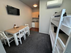 um quarto com uma mesa e um beliche em Snowhaven em Ohakune