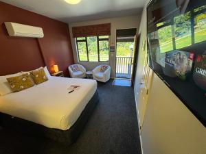 a hotel room with a bed and a flat screen tv at Snowhaven in Ohakune