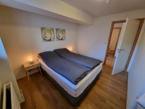a bedroom with a bed with two lights on it at K15 Apartment in Vestmannaeyjar