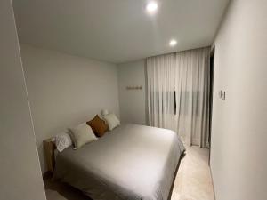 a bedroom with a white bed and a window at Keiken en el corazón de Chacras de Coria in Chacras de Coria +8 photos