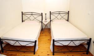 two twin beds in a room with wooden floors at Mary's Villas in Plomari