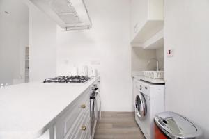 Una cocina blanca con lavadora y secadora. en LittleVenice modern one bed flat, en Londres