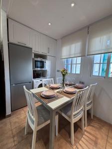 a kitchen with a table with chairs and a refrigerator at Breathtaking Sunsets Flat in Las Palmas de Gran Canaria