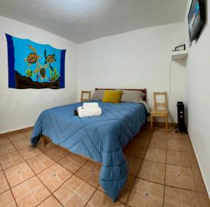 Schlafzimmer mit einem Bett mit blauer Decke in der Unterkunft Pura Vida! Ciudad Hidalgo in Ciudad Hidalgo