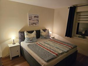 een slaapkamer met een bed met kussens en een raam bij Ferienwohnung Ostsee und Strand 1 in Ribnitz-Damgarten