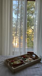 a tray of food on a bed in front of a window at Deribas Hotel in Odesa