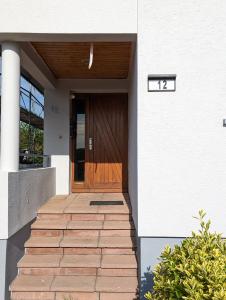 una puerta delantera de una casa con puerta de madera en Aux cigognes de Blotzheim en Blotzheim