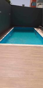 a swimming pool with blue water and a wooden floor at Techas Near Beach Apt with Pool in Praia