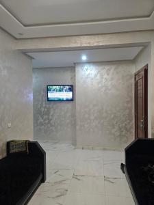 a living room with a tv on a wall at Appartement moderne près de la corniche in Nador