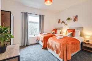 um quarto com 2 camas e uma janela em Stylish & Vibrant 2 BR Retreat Manchester em Manchester