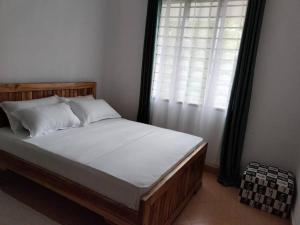 a bedroom with a large bed with a window at Stay with Adhiambo in Kilifi