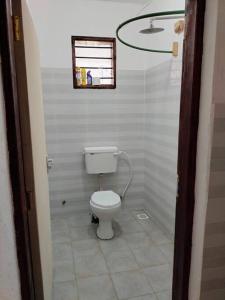 a small bathroom with a toilet and a window at Stay with Adhiambo in Kilifi