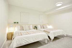 two beds in a room with white walls at Loft Deluxe & Fun - Downtown Quebec in Quebec City