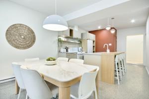 a kitchen and dining room with a white table and chairs at Loft Deluxe & Fun - Downtown Quebec in Quebec City