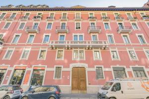 un edificio rosa con macchine parcheggiate di fronte di Barbara's house - Milano Navigli - 2 km from Duomo a Milano