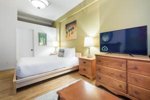 um quarto com uma cama e uma televisão de ecrã plano em Le Haute Ville em Cidade de Quebec
