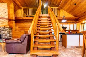 a staircase in a cabin with a couch and a kitchen at Riverbend Cottage & RV Resort in Parksville