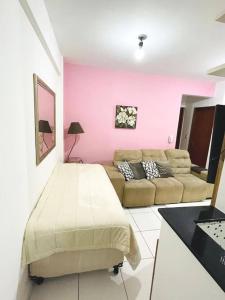 a living room with a bed and a couch at Apartamento Aconchegante Centro de Poços de Caldas in Poços de Caldas