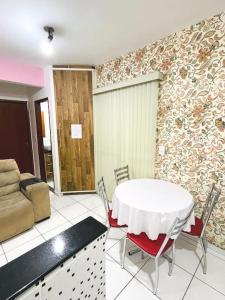 Zimmer mit einem Tisch, Stühlen und einem Sofa in der Unterkunft Apartamento Aconchegante Centro de Poços de Caldas in Poços de Caldas