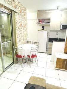 波蘇斯迪卡爾達斯的住宿－Apartamento Aconchegante Centro de Poços de Caldas，厨房配有桌椅和冰箱。
