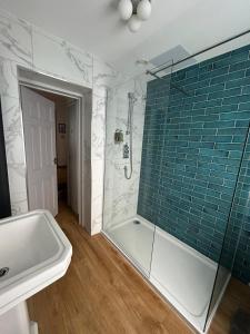 een badkamer met een bad, een wastafel en een douche bij Apartment 4 at Number 8 in City centre with kitchenette in Kent
