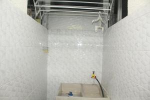 uma casa de banho em azulejos brancos com um chuveiro e uma mangueira em APARTAMENTO CESAR CONTO em Quibdó