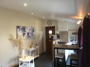une cuisine avec un comptoir, une table et des chaises dans l'établissement La Tour de Flandre, à Rousseloy 15 autres photos