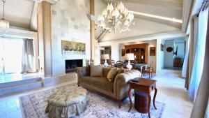 un soggiorno con divano e tavolo di LA DOLCE VITA VILLA 3 en-suites+large living spaces+glorious outdoor space:managed by Greenday a Rancho Mirage