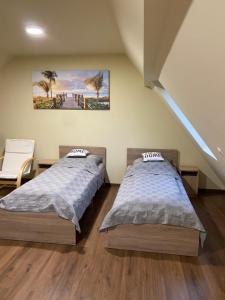 Un dormitorio con 2 camas y una escalera sin ascensor. en Pompa Villa, en Galyatető