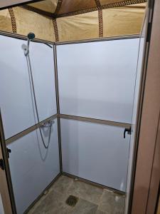 a shower with glass doors in a room at Najma Luxury Camp in Merzouga