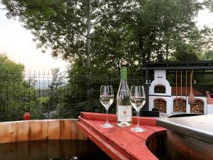 2 verres à vin assis sur une table avec une bouteille de vin dans l'établissement Pompa Villa, à Galyatető