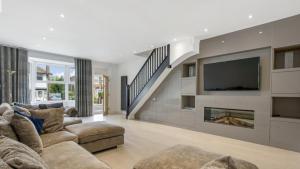 uma sala de estar com um sofá e uma lareira em Newly refurbished 3 bedroom property in north london em East Barnet