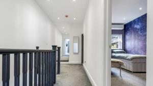 un pasillo con una escalera y una cama en una habitación en Newly refurbished 3 bedroom property in north london, en East Barnet