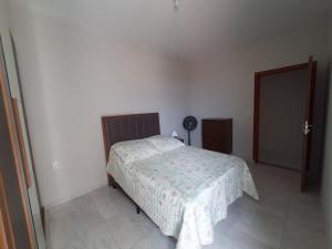 a bedroom with a bed in a white room at Apartamento Aconchego nas Montanhas, em Cunha-SP in Cunha