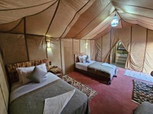 a bedroom with two beds in a tent at Najma Luxury Camp in Merzouga