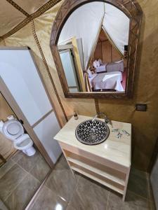 a bathroom with a sink and a mirror in a tent at Najma Luxury Camp in Merzouga