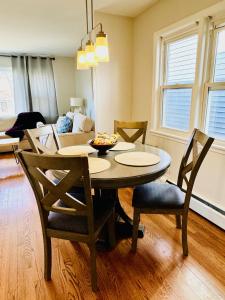a dining room table and chairs in a living room at Charming and Convenient 3br 1ba apt - fully furnished and equipped - fast Internet in Forest Park